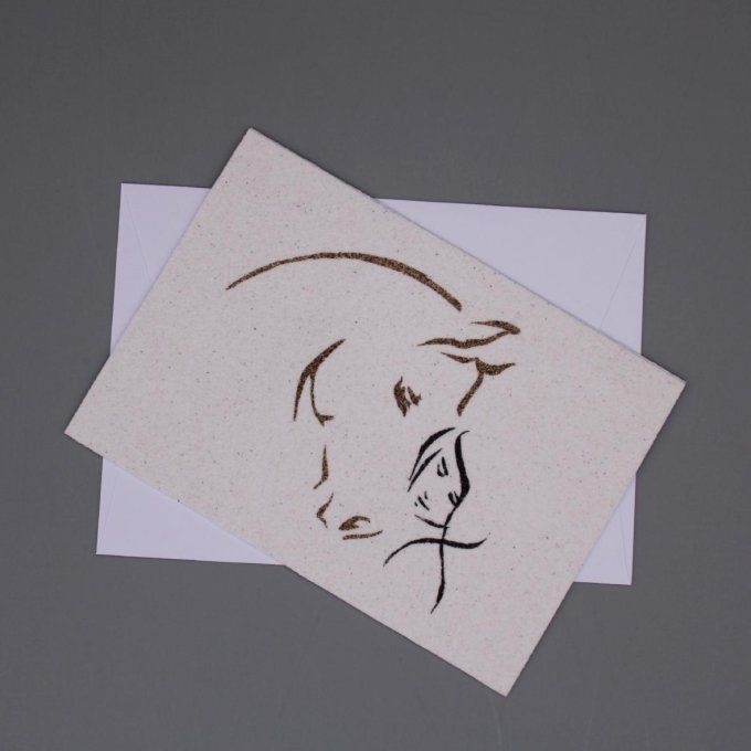 Carte de vœux en sable représentant une cavalière câlinant la tête de son cheval, illustrant leur co