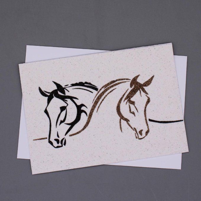 Carte de vœux en sable montrant deux têtes de chevaux stylisées, en noir et brun.