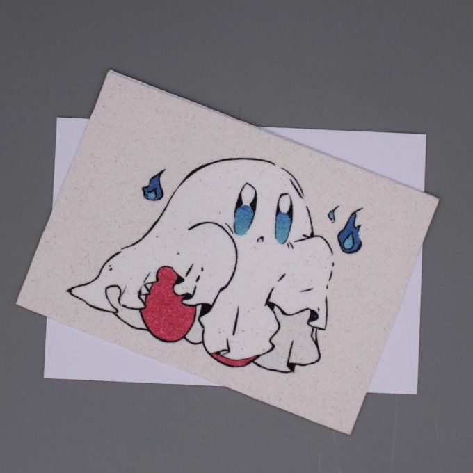 Carte d’Halloween montrant un petit fantôme blanc aux yeux bleus tenant un cœur rouge, réalisée en s