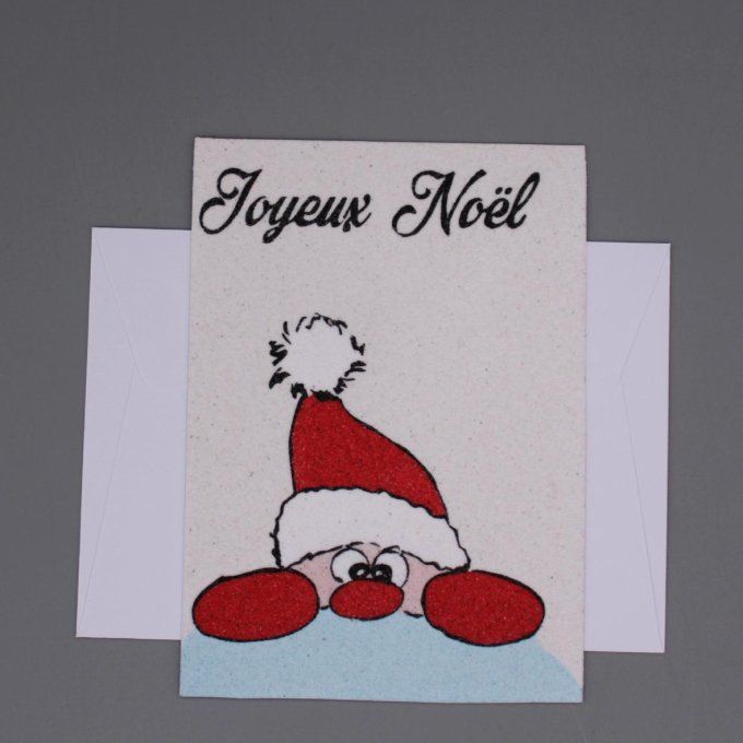 Carte de Noël en sable représentant un lutin caché derrière un muret, portant un bonnet rouge avec «