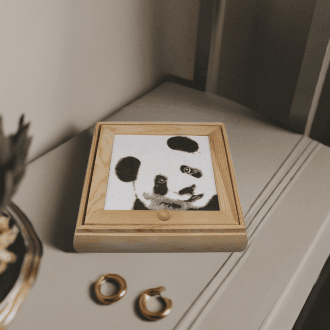 Coffret à bijoux fait main – Illustration de panda en sable – posé sur un meuble raffiné