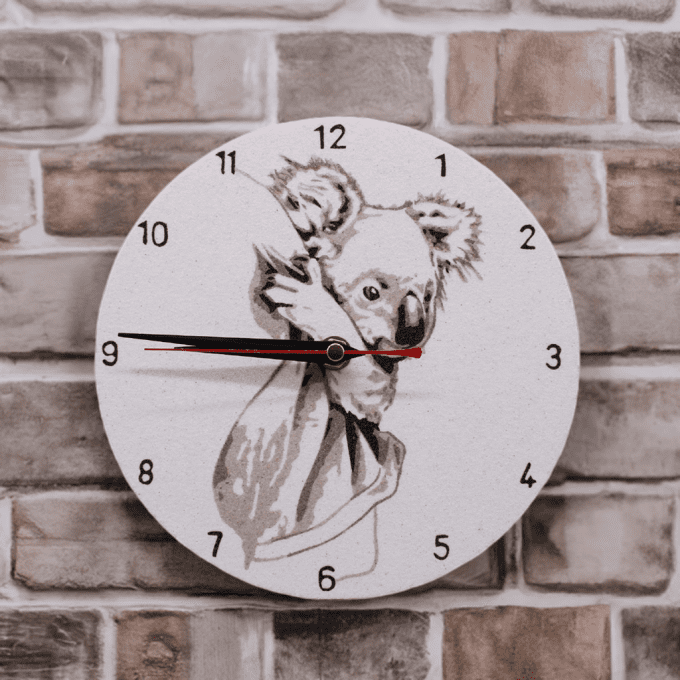 Horloge artisanale en sable – Koala et son petit sur fond de briques claires