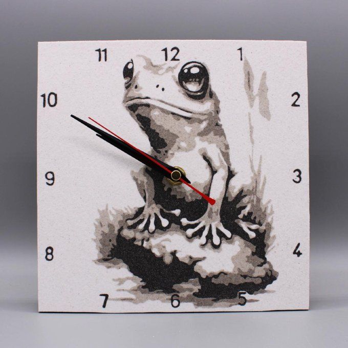 Horloge carrée « Grenouille » représentant une grenouille en sable assise sur un rocher