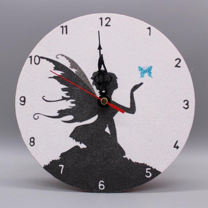 Horloge ronde « Fée enchantée » avec une fée à genoux et un papillon turquoise