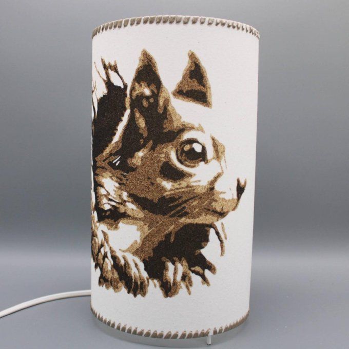 Lampe cylindre Écureuil enchanteur – Écureuil sortant d’un tronc, réalisée en sable