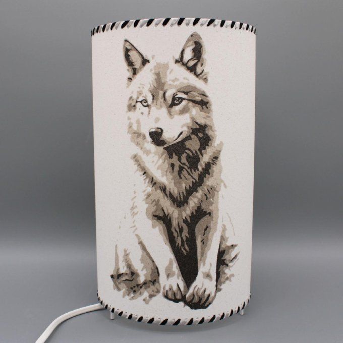 lampe cylindre - Loup solitaire, un loup assis, réalisé en sable, tons gris