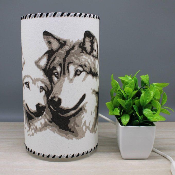 Lampe cylindre Tendresse sauvage – deux loups amoureux, réalisée en sable, tons gris, dans décor