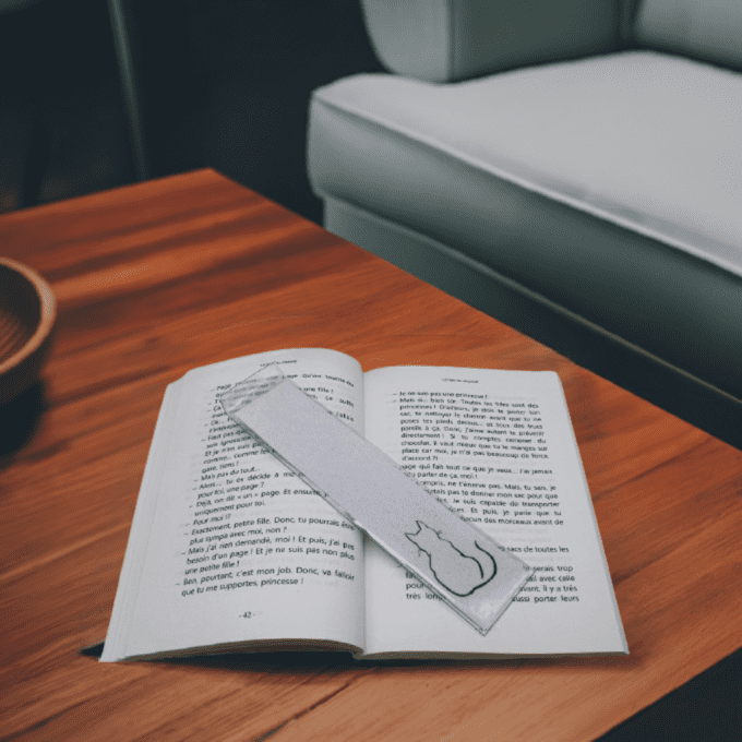 Marque-pages chat en sable sur livre ouvert