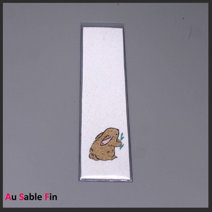 Marque-page lapin brun en sable sentant une branche de feuilles vertes