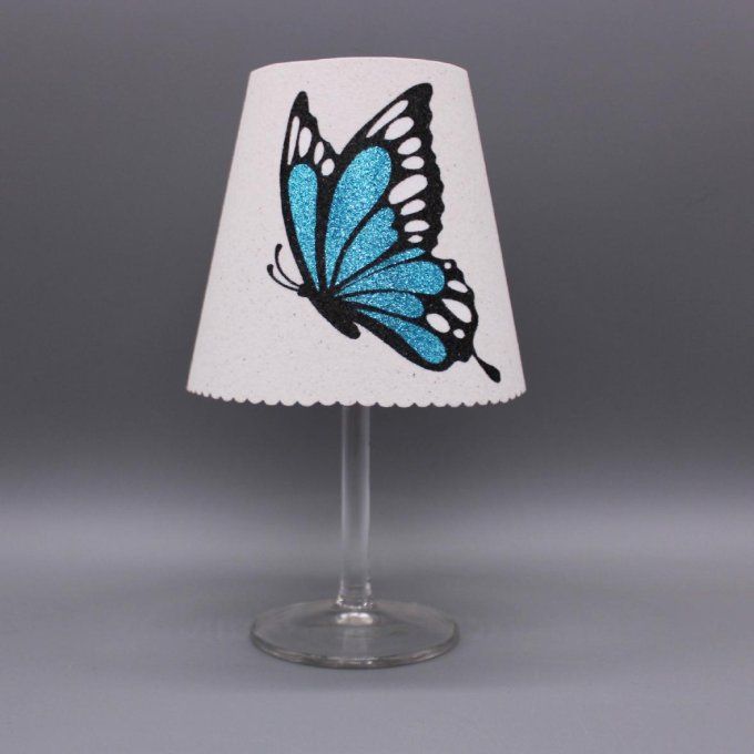 Photophore artisanal « Papillon aile fermée » aux ailes pailletées en 5 coloris sur fond blanc.
