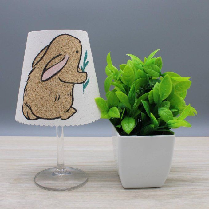 Photophore « Lapin » représentant un lapin tenant une brindille, en sable noir et naturel.