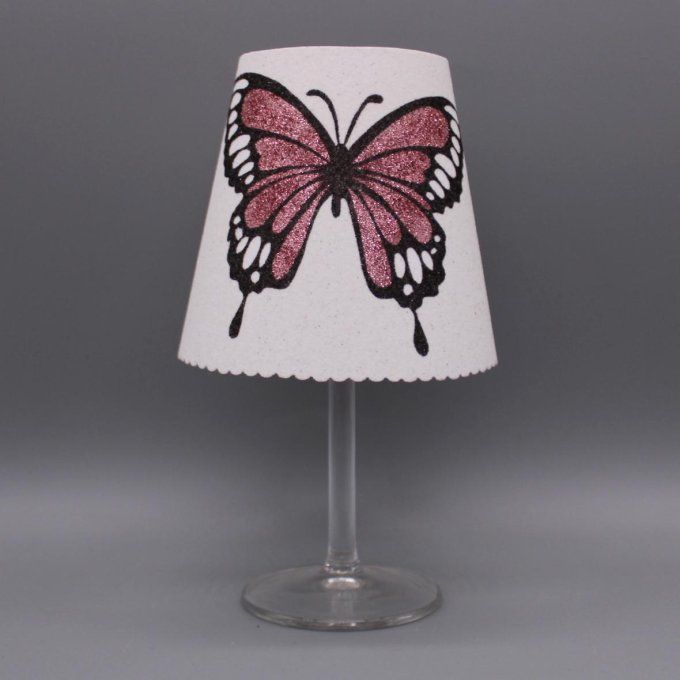 Photophore artisanal « Papillon ailes ouvertes » avec paillettes colorées rose sur fond blanc.