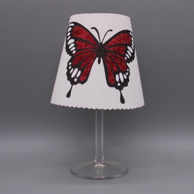Photophore artisanal « Papillon ailes ouvertes » avec paillettes colorées rouge sur fond blanc.