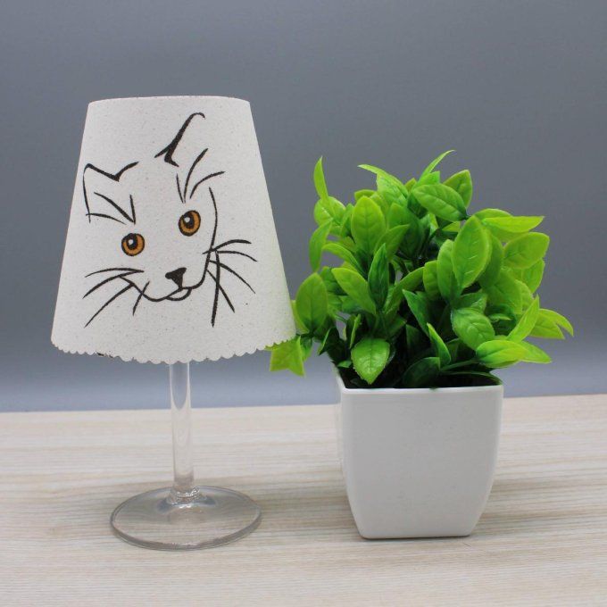 Photophore « Chat » représentant une tête de chat avec yeux orange sur fond blanc.