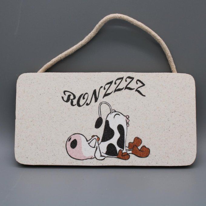 Plaque de porte Ronzzz avec une vache couchée en sable coloré sur fond naturel