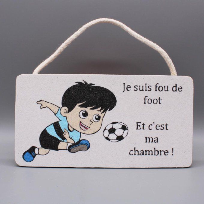 Plaque de porte Je suis fou de foot avec un garçon en train de shooter dans un ballon