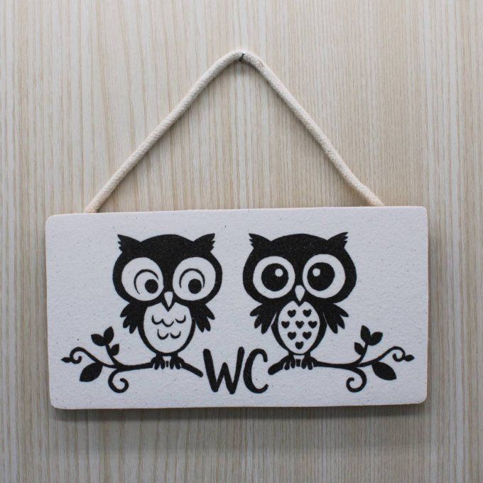Plaque WC décorative avec deux hiboux noirs sur fond blanc, suspendue sur porte bois clair
