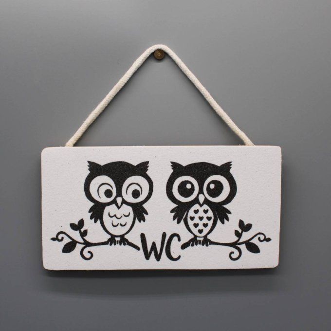 Plaque WC avec deux chouettes noires sur fond blanc en sable