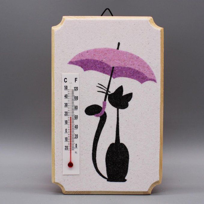Thermomètre "Chat sous la pluie" représentant un chat noir sous parapluie mauve, en sable sur bois.